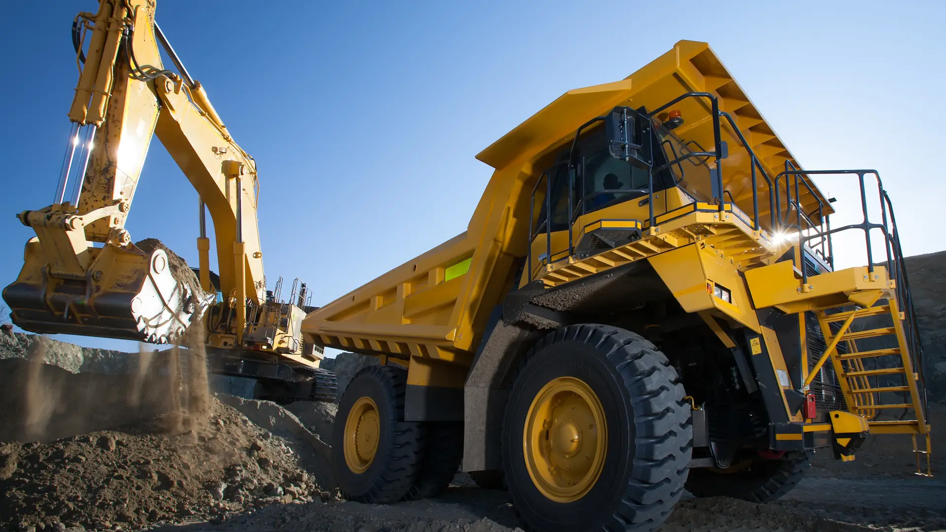 An excavator loading a mining dump truck